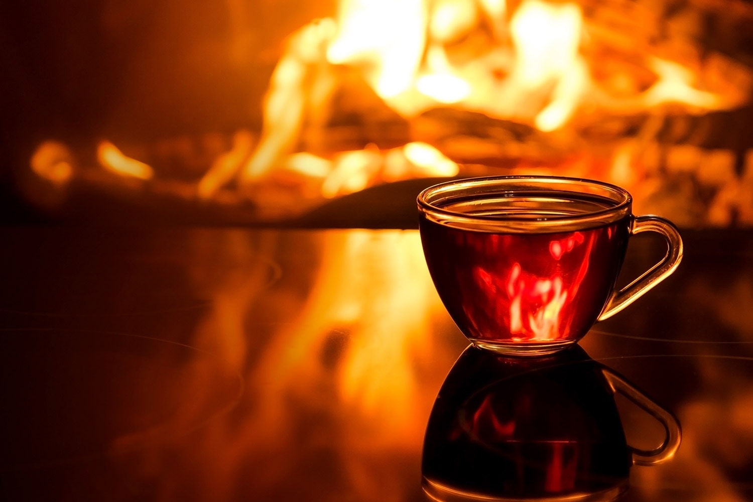 Warme Tasse Tee am Kaminfeuer